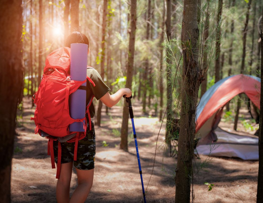 Hiker in the woods with a back pack and a tent