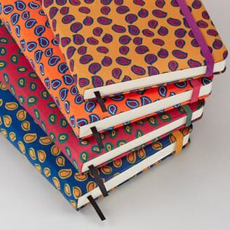 Pile of moleskin journals with different colourful patterns